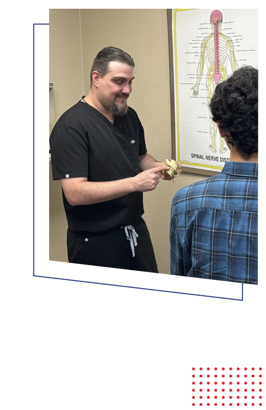 Dr. Brian Long demonstrating vertebral function during a patient consultation.