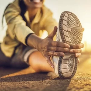Athlete stretching outdoors, focusing on improving flexibility and preventing injury.